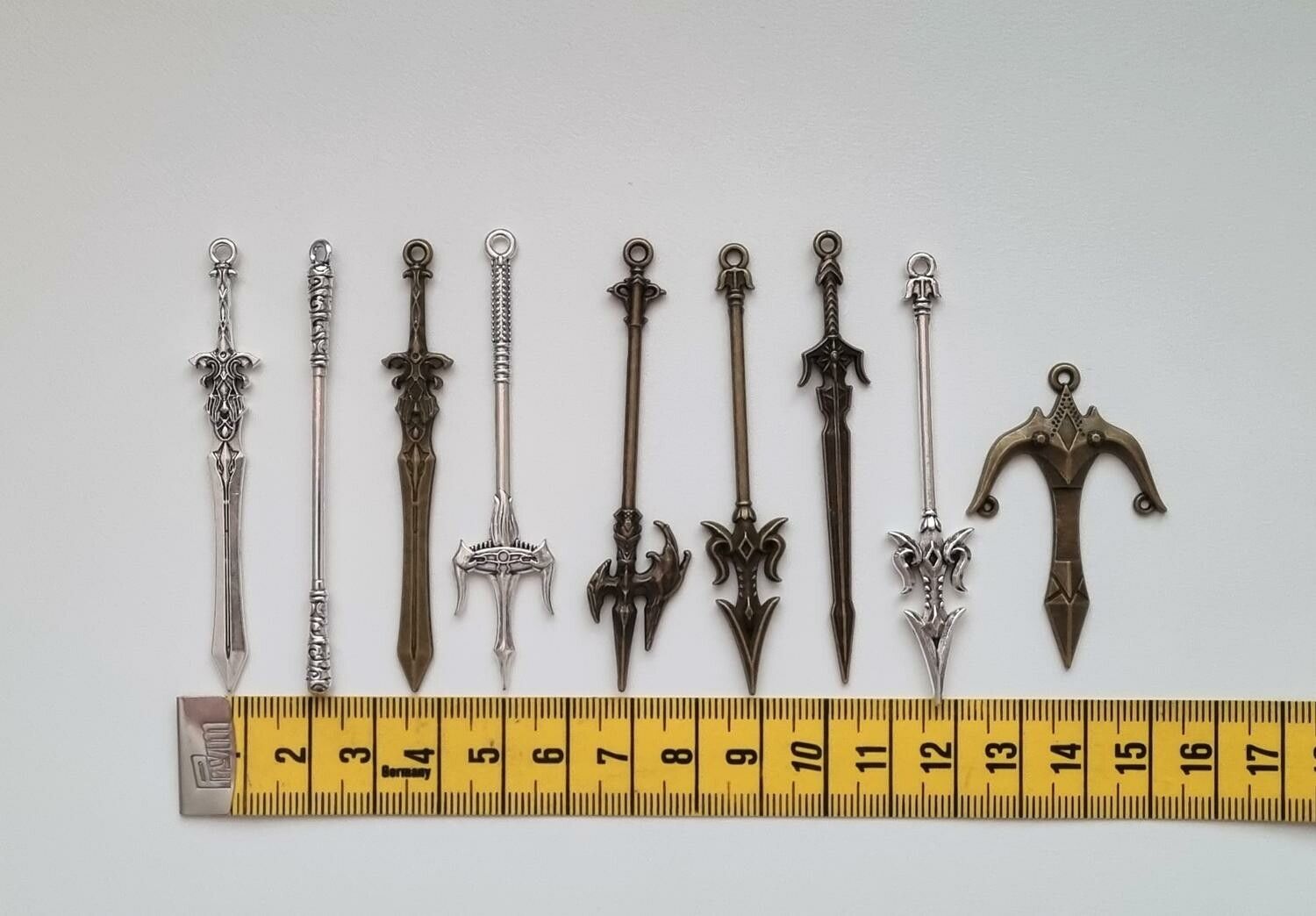 9 st berlocker - Miniatyrvapen, minisvärd, treuddar med mera. Fina miniatyrer