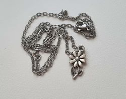 Silverfärgat halsband med en blomma, berlock / charm