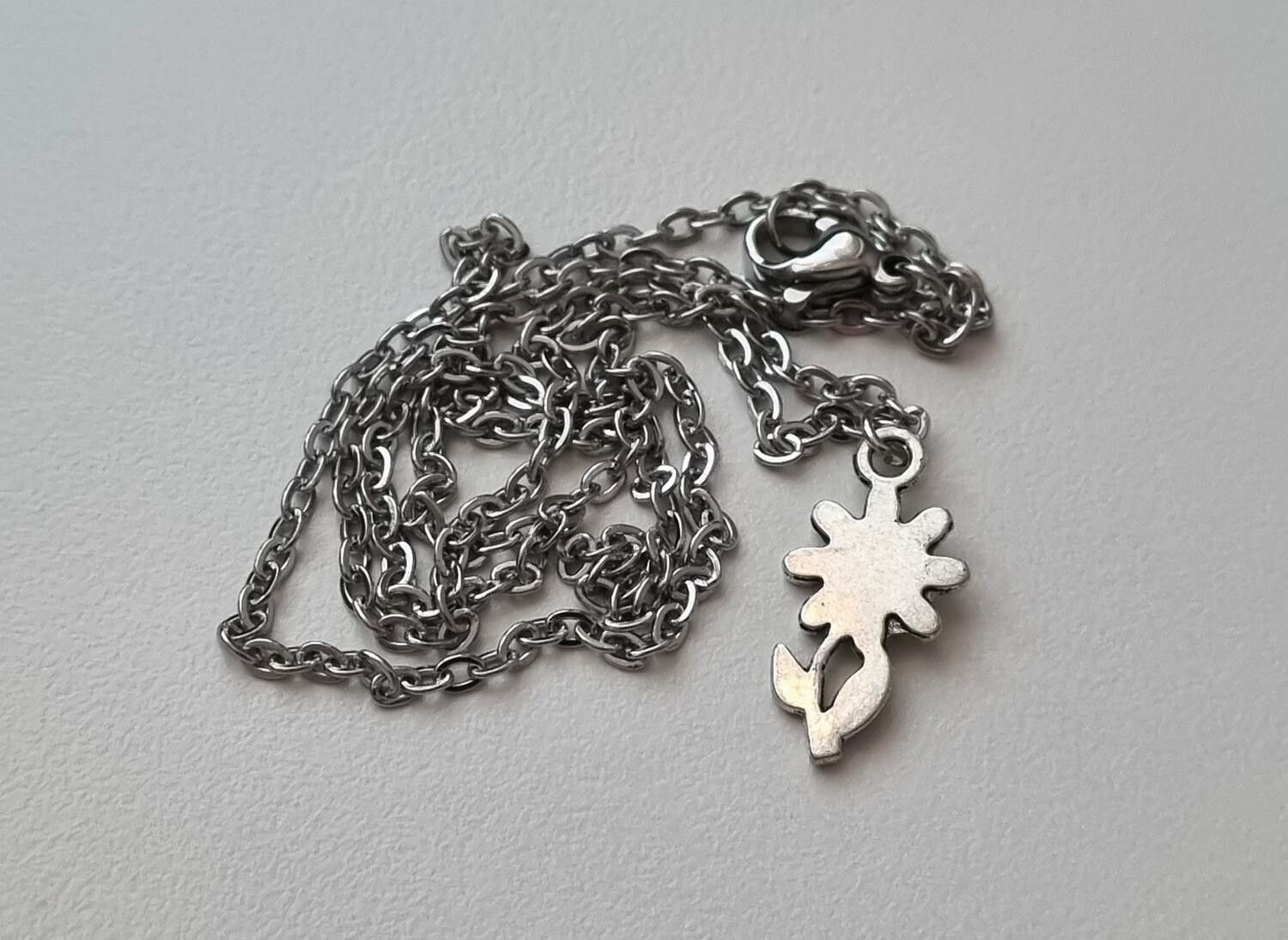 Silverfärgat halsband med en blomma, berlock / charm