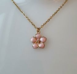 Guldfärgat halsband med en rosa blomma, blomberlock / charm