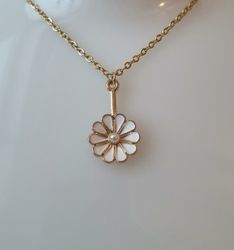 Guldfärgat halsband med en vit blomma, blomberlock / charm