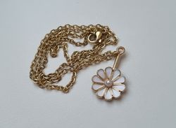 Guldfärgat halsband med en vit blomma, blomberlock / charm