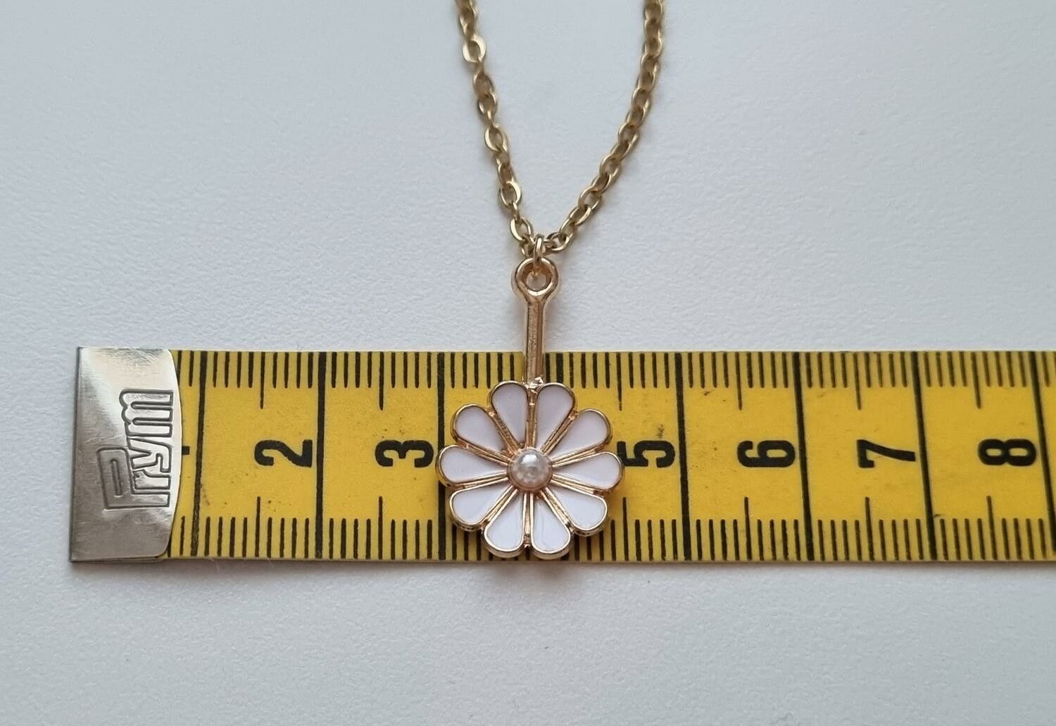 Guldfärgat halsband med en vit blomma, blomberlock / charm