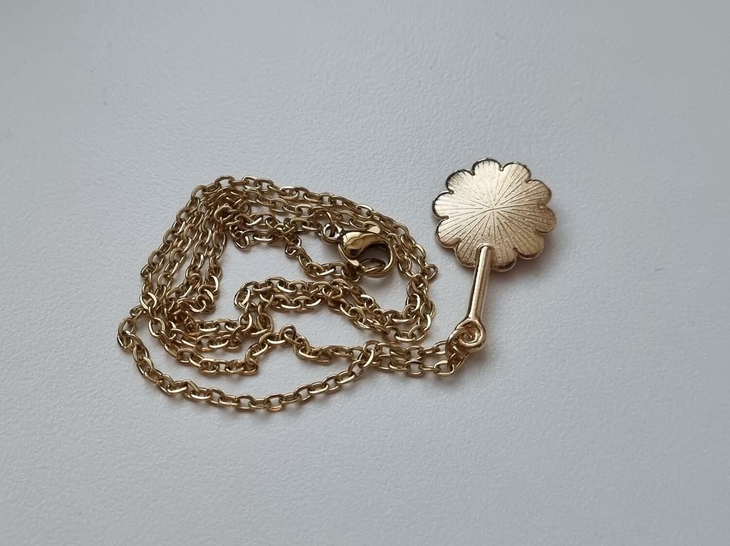 Guldfärgat halsband med en rosa blomma, blomberlock / charm