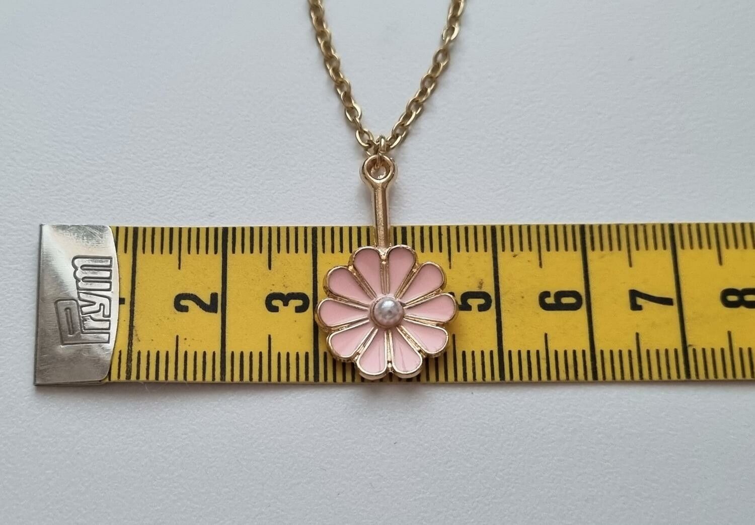 Guldfärgat halsband med en rosa blomma, blomberlock / charm