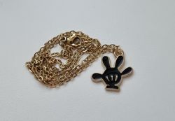 Guldfärgat halsband med en svart hand, berlock / charm