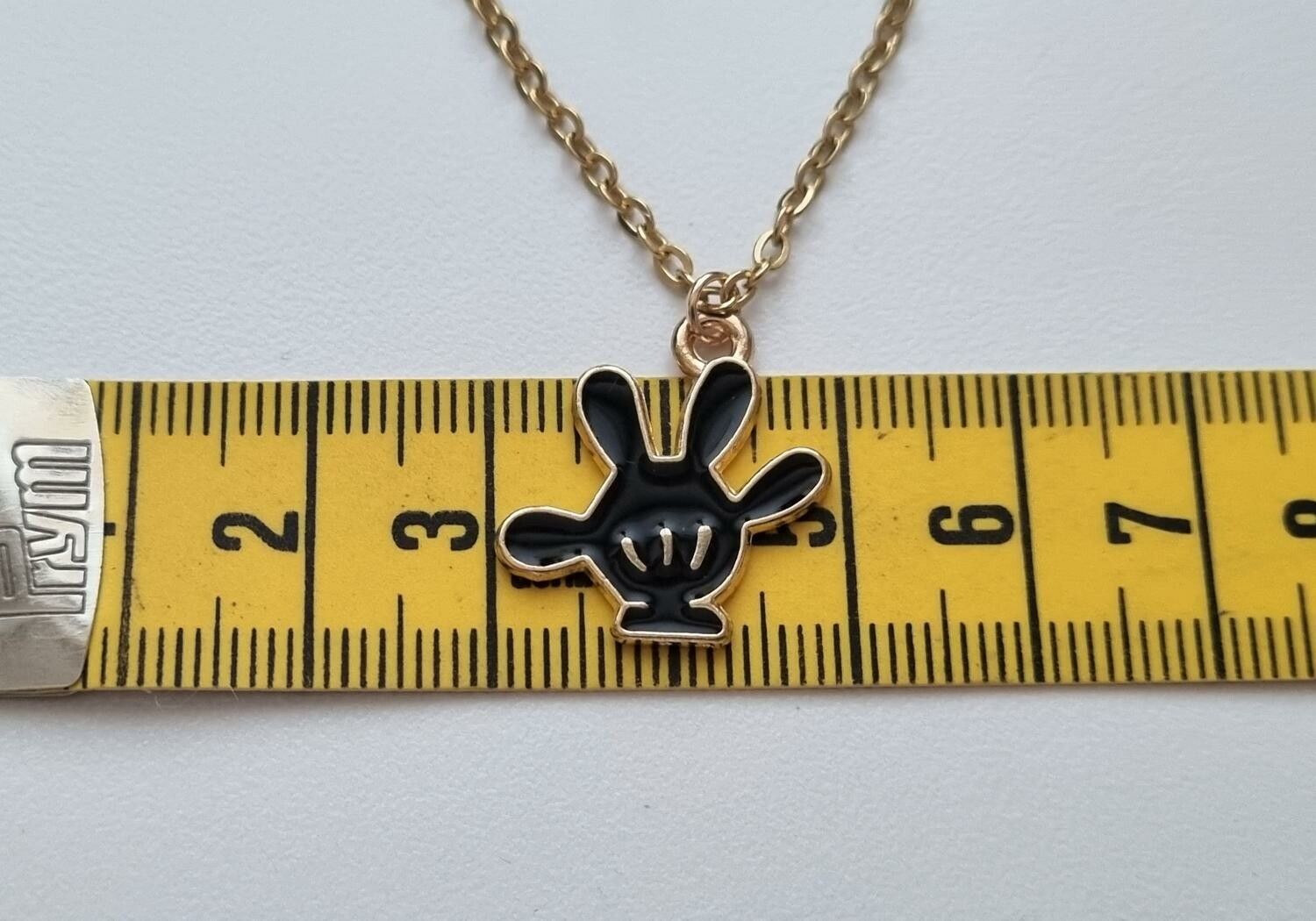 Guldfärgat halsband med en svart hand, berlock / charm
