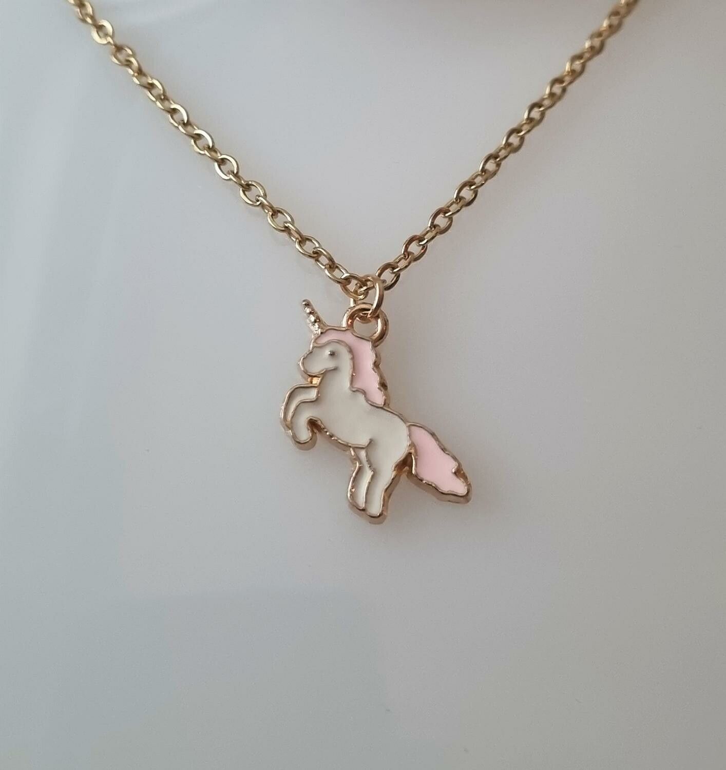 Guldfärgat halsband med en rosa enhörning, berlock / charm