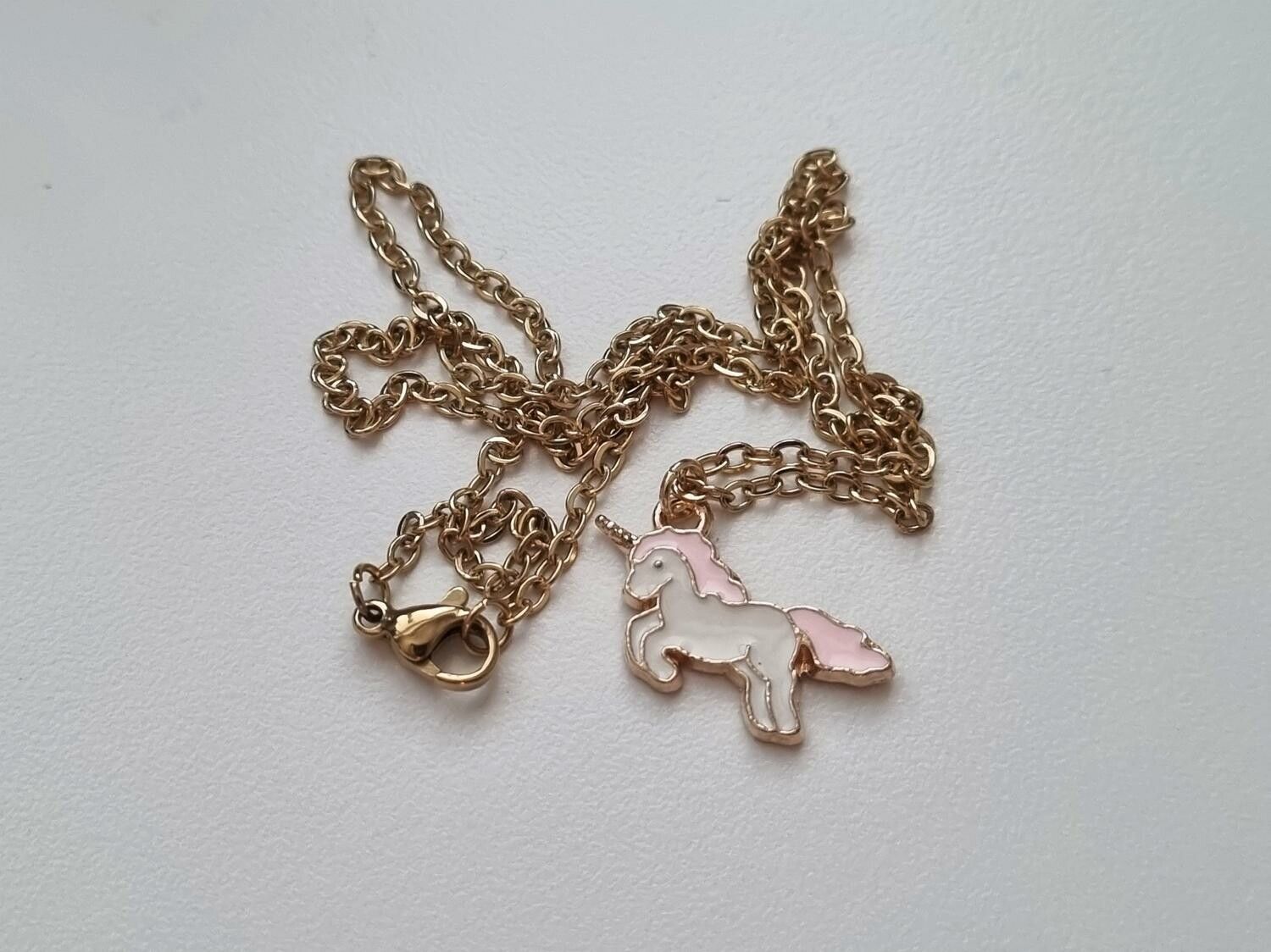 Guldfärgat halsband med en rosa enhörning, berlock / charm