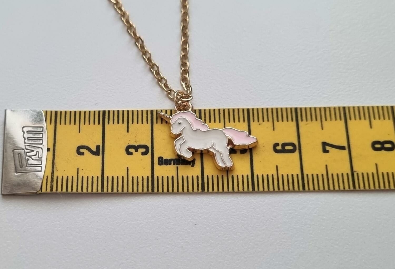 Guldfärgat halsband med en rosa enhörning, berlock / charm