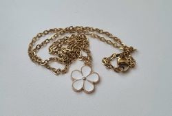 Guldfärgat halsband med en vit blomma, blomberlock / charm