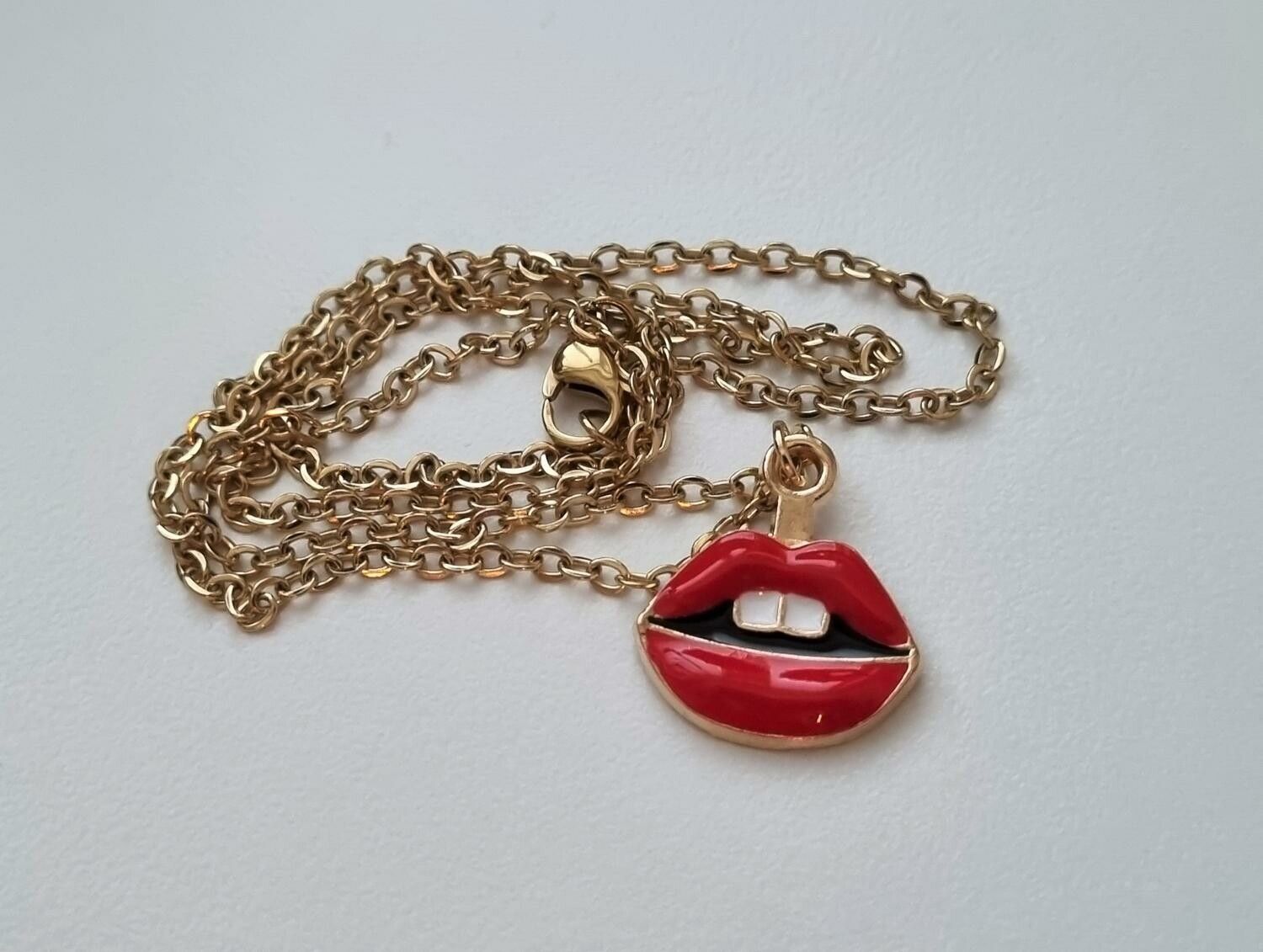 Guldfärgat halsband med röda läppar,, berlock / charm