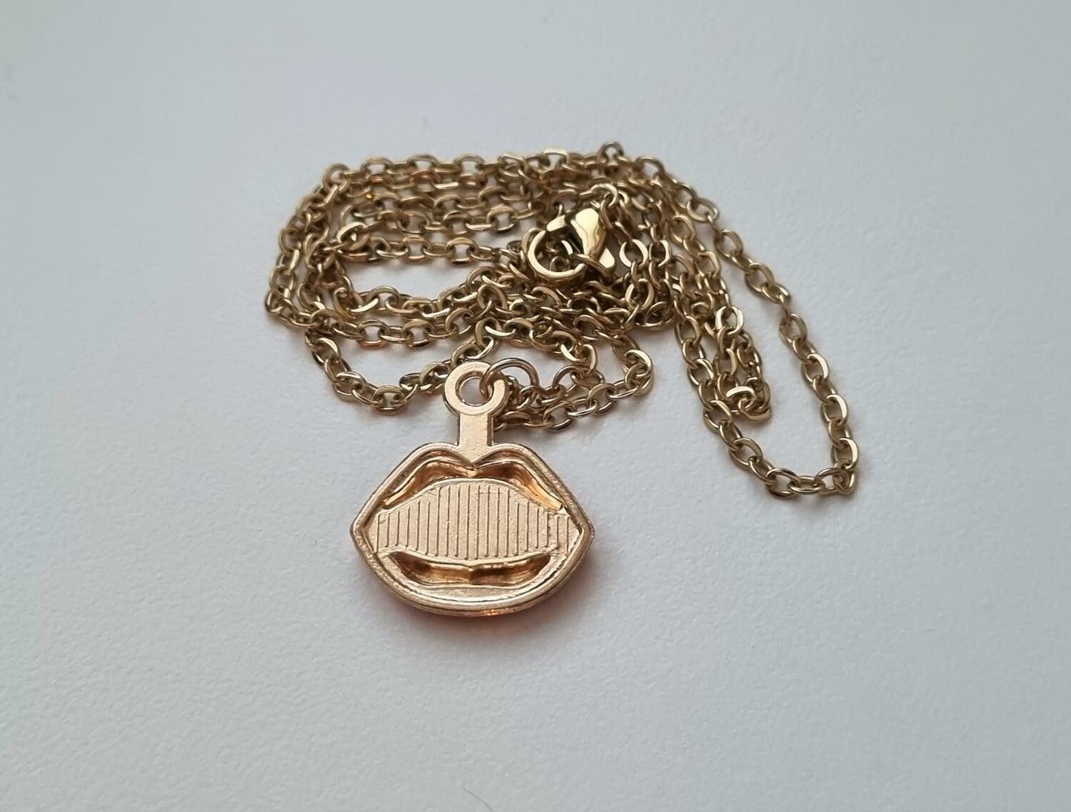 Guldfärgat halsband med röda läppar,, berlock / charm