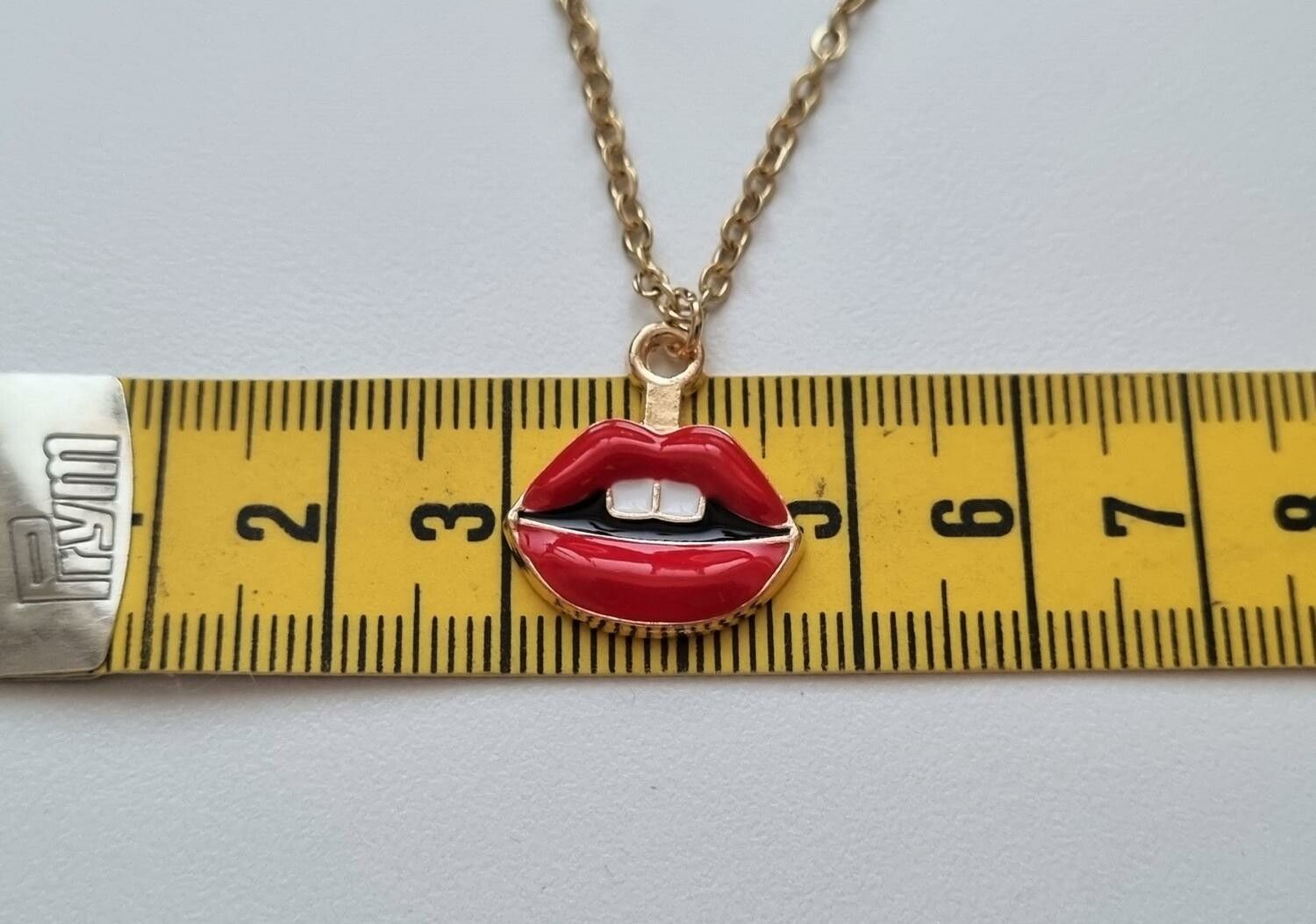 Guldfärgat halsband med röda läppar,, berlock / charm