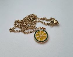 Guldfärgat halsband med en rund berlock / charm