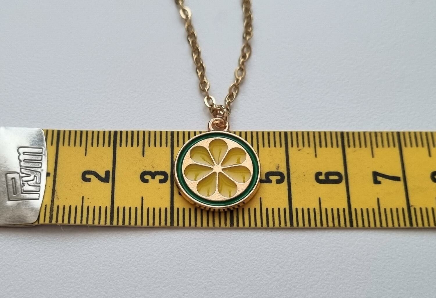 Guldfärgat halsband med en rund berlock / charm