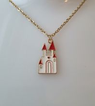 Guldfärgat halsband med ett vitt slott. Berlock / charm