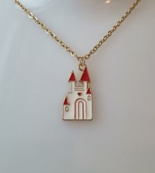 Guldfärgat halsband med ett vitt slott. Berlock / charm