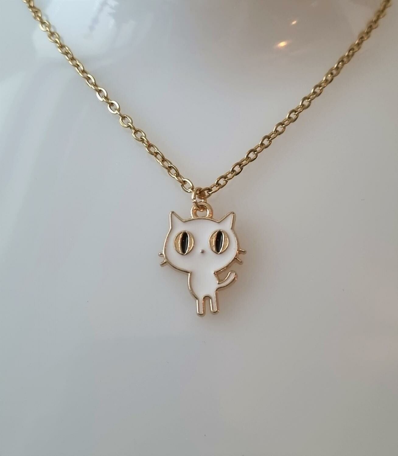Guldfärgat halsband med en vit katt som berlock / charm