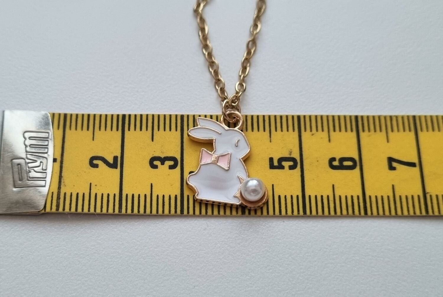 Guldfärgat halsband med en vit kanin, kaninberlock / charm