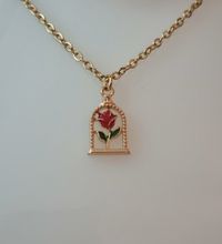 Guldfärgat halsband (50 cm) med en röd ros i en bur