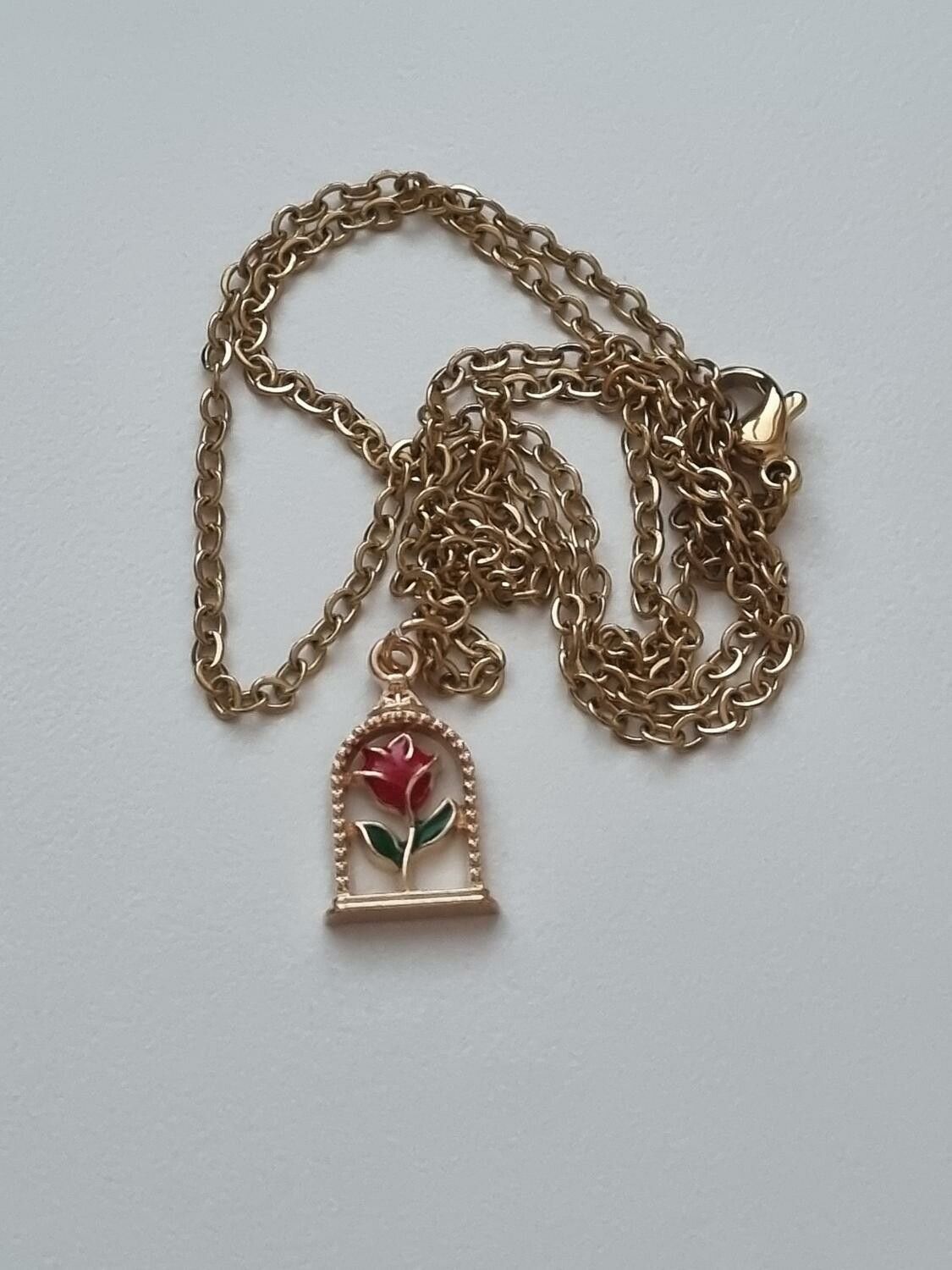 Guldfärgat halsband (50 cm) med en röd ros i en bur