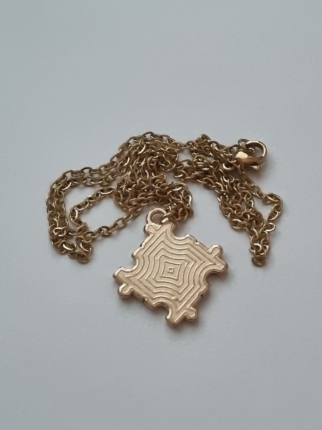 Guldfärgat halsband (50 cm) med en pusselbit / medvetenhet