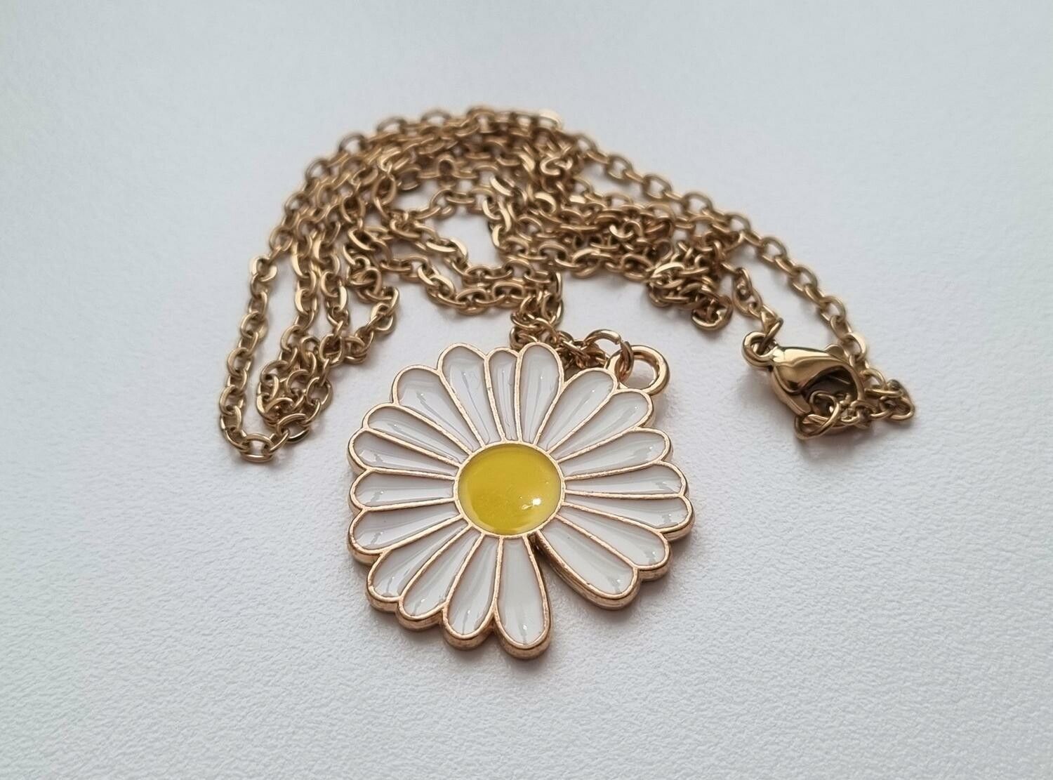 Guldfärgat halsband (50 cm) med en vit blomma
