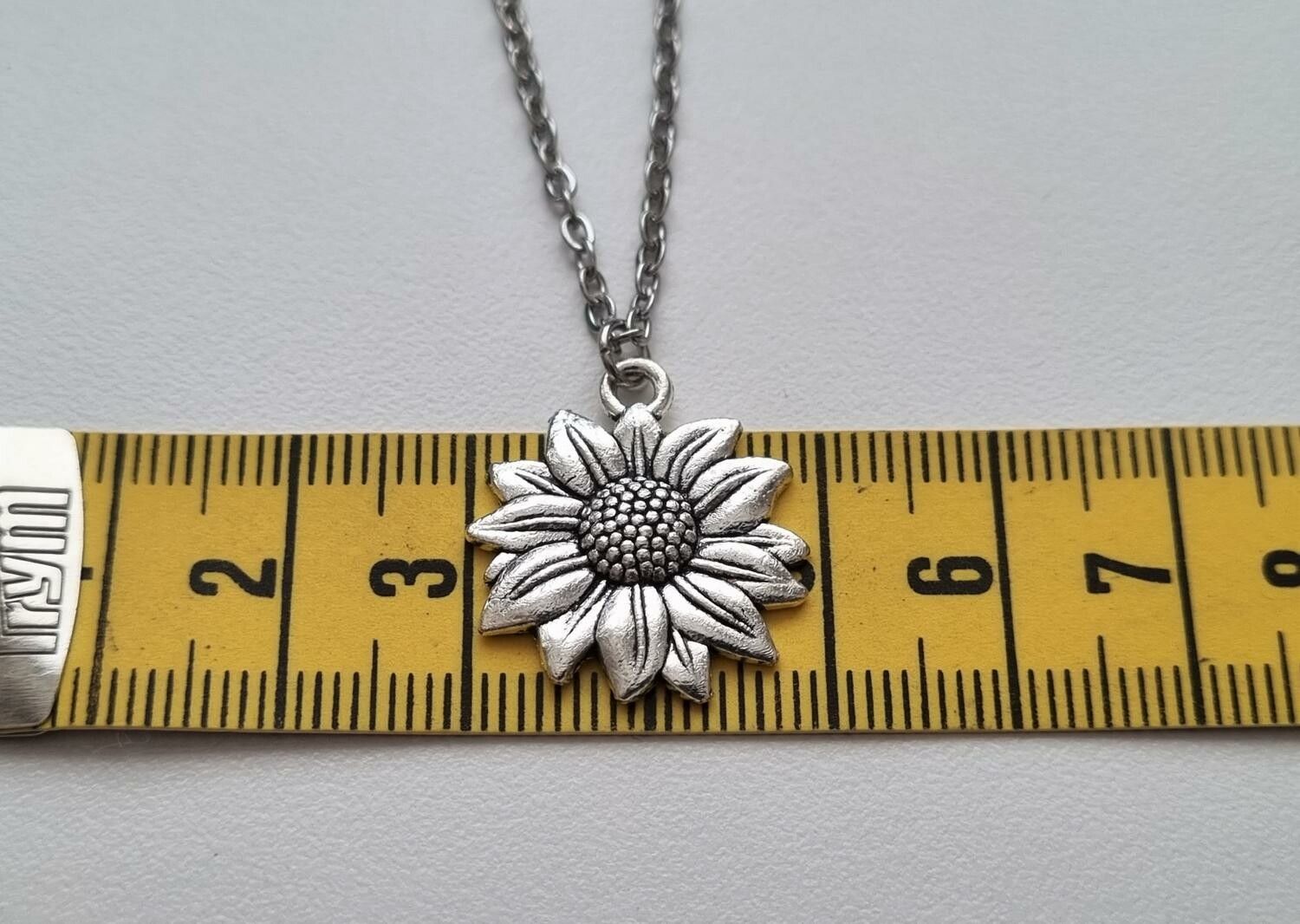 Silverfärgat halsband (50 cm) med en blomma / solros