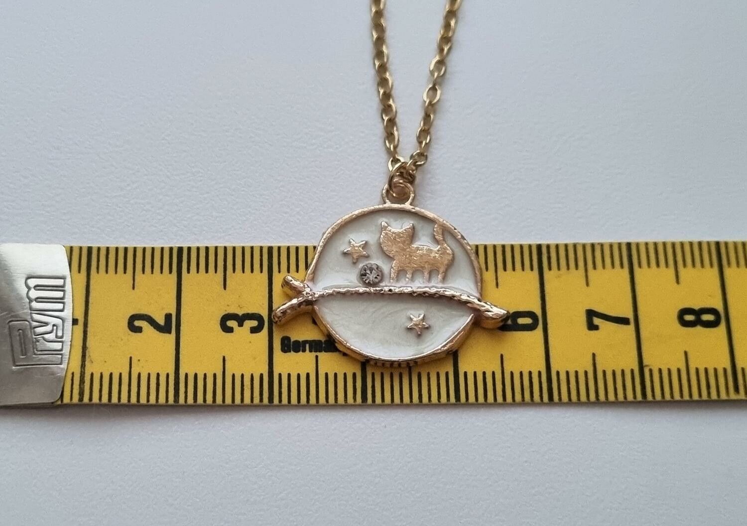 Guldfärgat halsband (45 cm) med en söt vit berlock