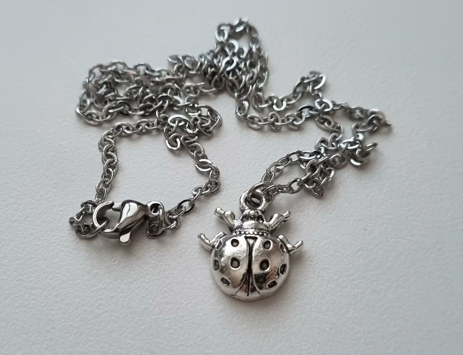 Silverfärgat halsband (45 cm) med en liten nyckelpiga