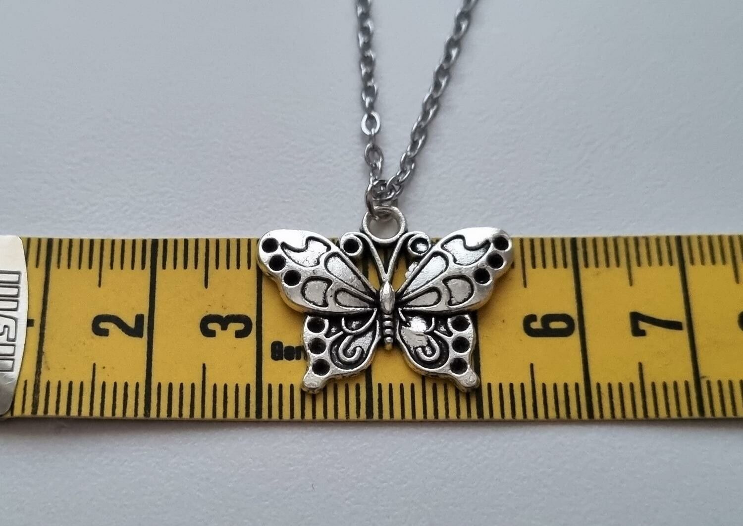 Silverfärgat halsband (45 cm) med en fjäril