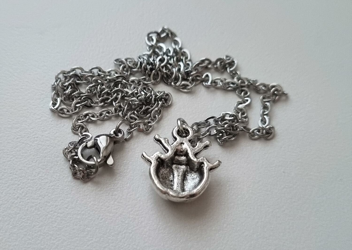 Silverfärgat halsband (45 cm) med en liten nyckelpiga