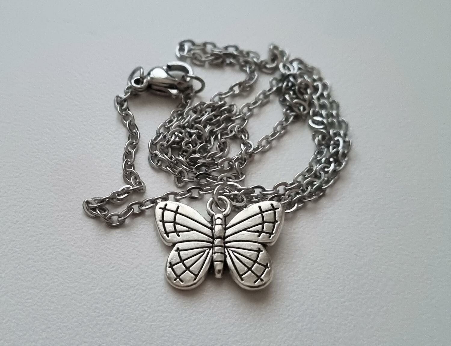 Silverfärgat halsband (45 cm) med en söt fjäril