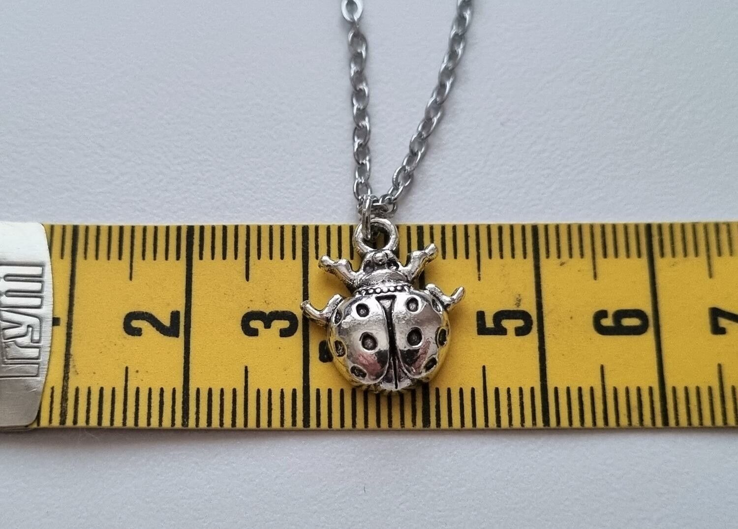 Silverfärgat halsband (45 cm) med en liten nyckelpiga