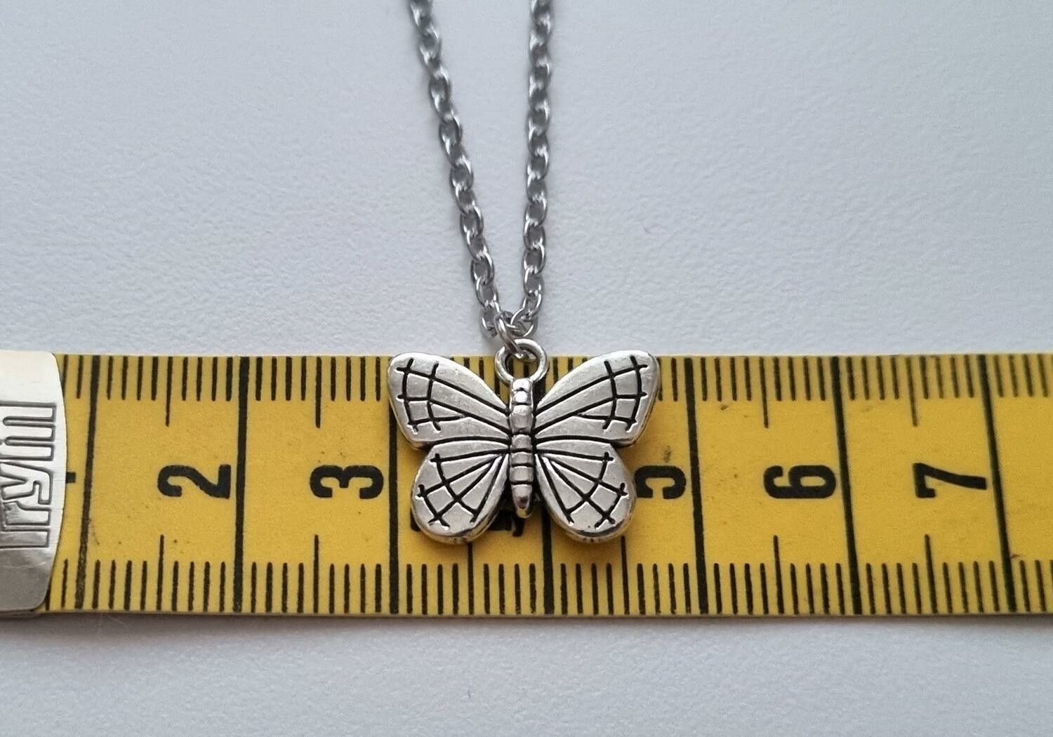 Silverfärgat halsband (45 cm) med en söt fjäril