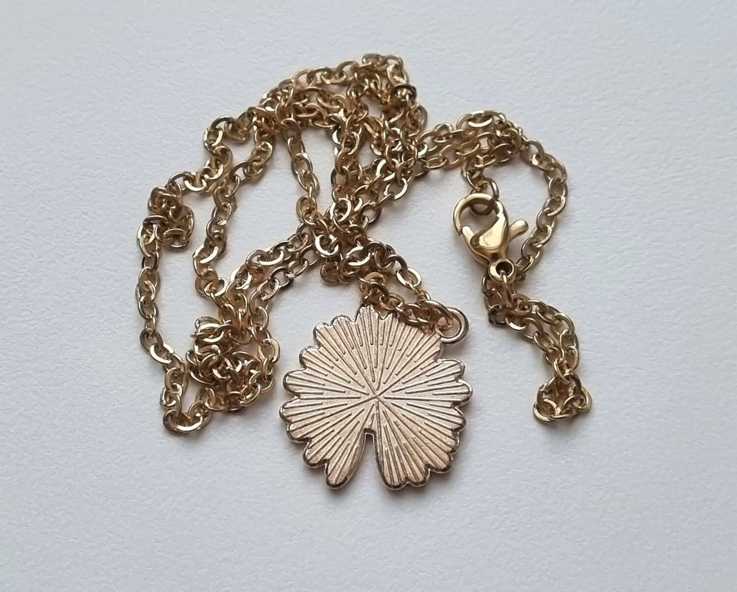 Guldfärgat halsband (50 cm) med en söt grön blomma som berlock