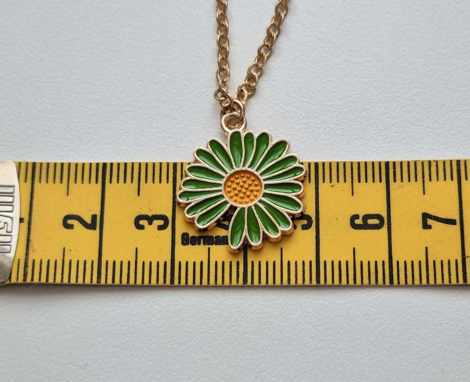 Guldfärgat halsband (50 cm) med en söt grön blomma som berlock