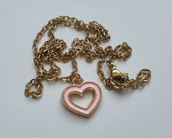 Guldfärgat halsband i rostfritt stål med ett rosa hjärta