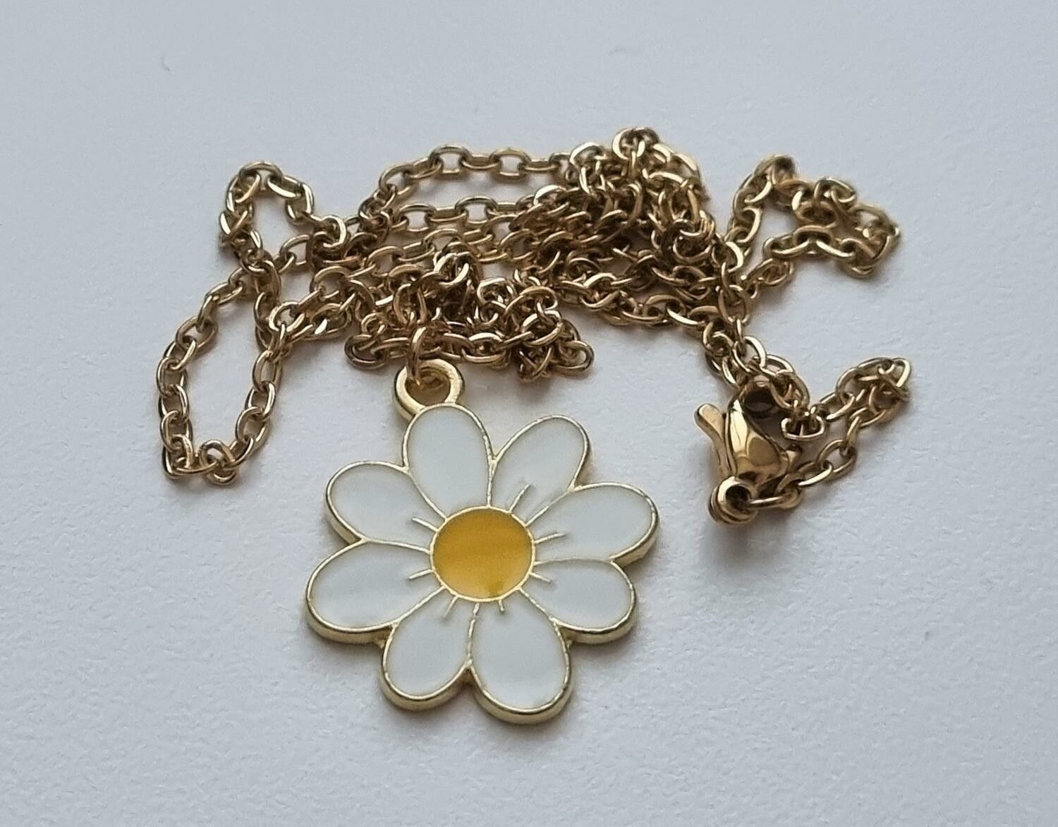 Guldfärgat halsband i rostfritt stål med vit blomma / tusensköna