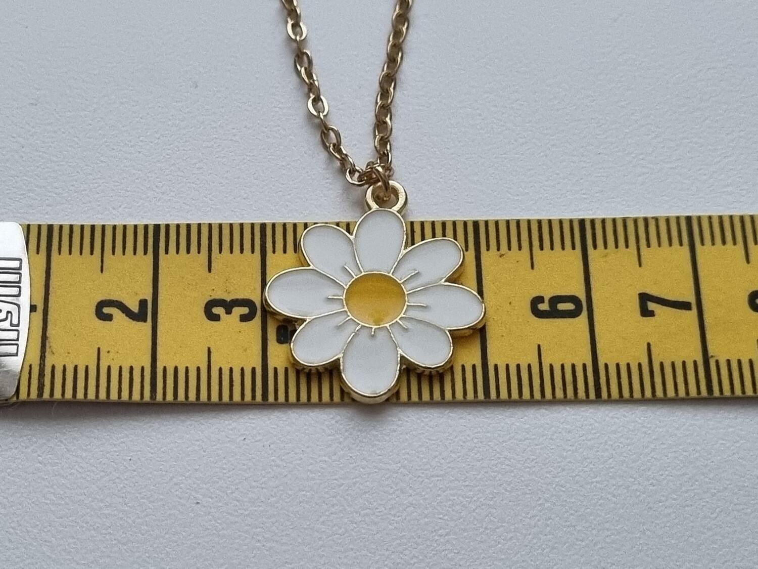 Guldfärgat halsband i rostfritt stål med vit blomma / tusensköna
