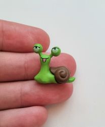 1 st grön snigel med brunt skal. Miniatyr / figurin för dekoration