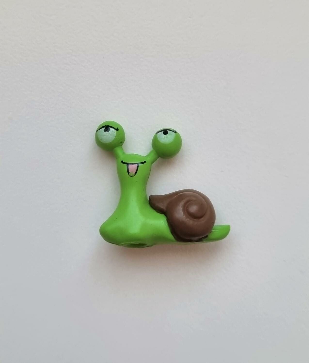 1 st grön snigel med brunt skal. Miniatyr / figurin för dekoration
