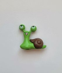 1 st grön snigel med brunt skal. Miniatyr / figurin för dekoration