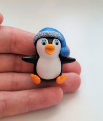Pingvin med en blå tomteluva. Miniatyr / figur för dekoration