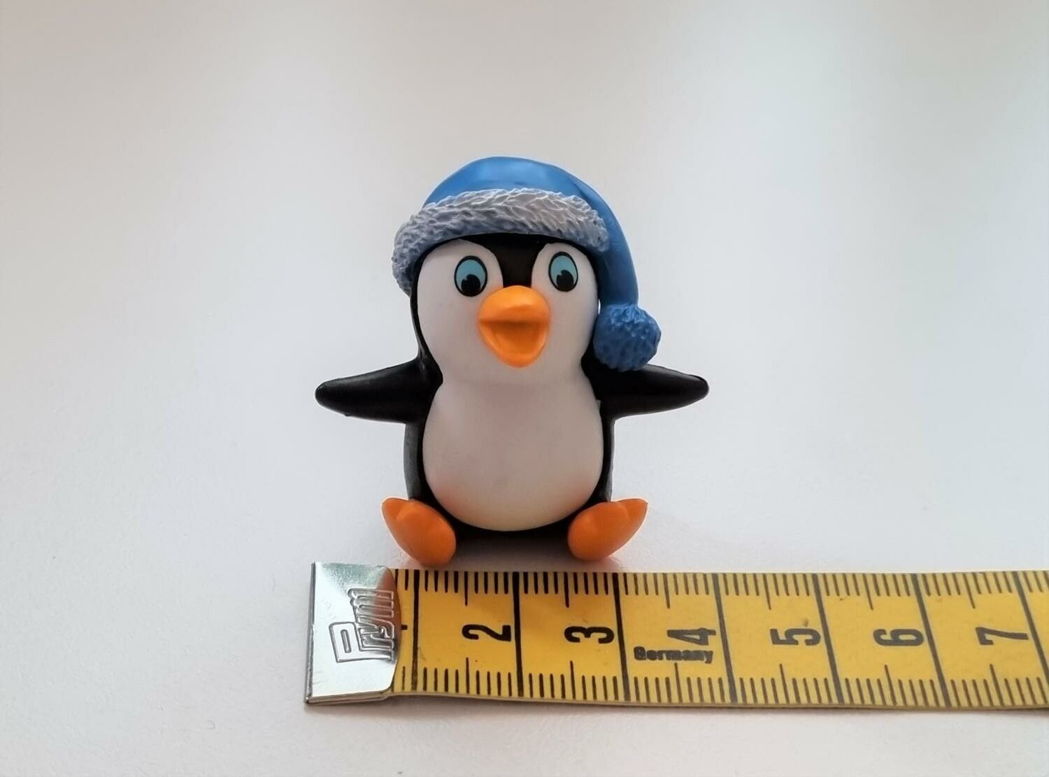 Pingvin med en blå tomteluva. Miniatyr / figur för dekoration