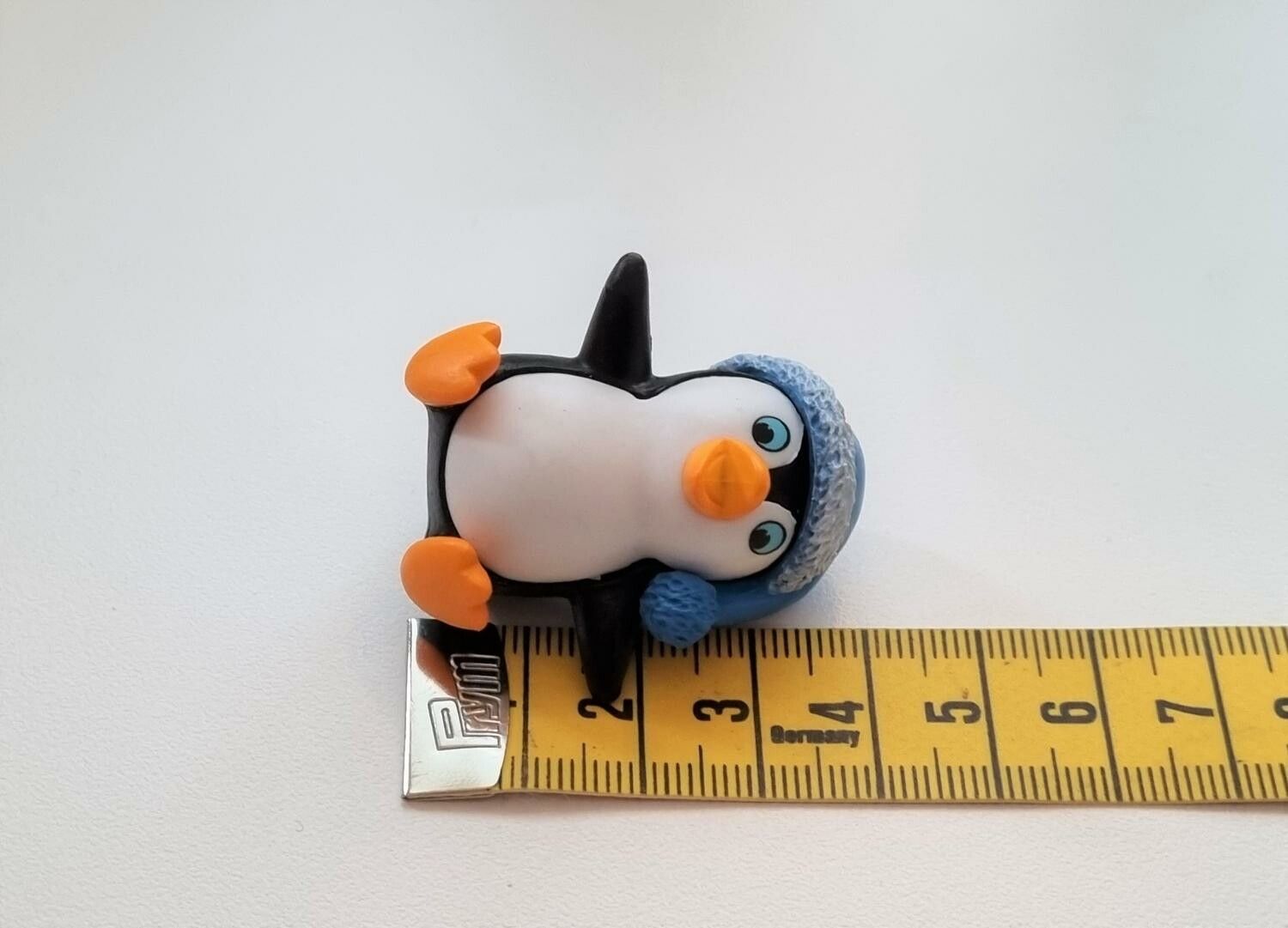 Pingvin med en blå tomteluva. Miniatyr / figur för dekoration