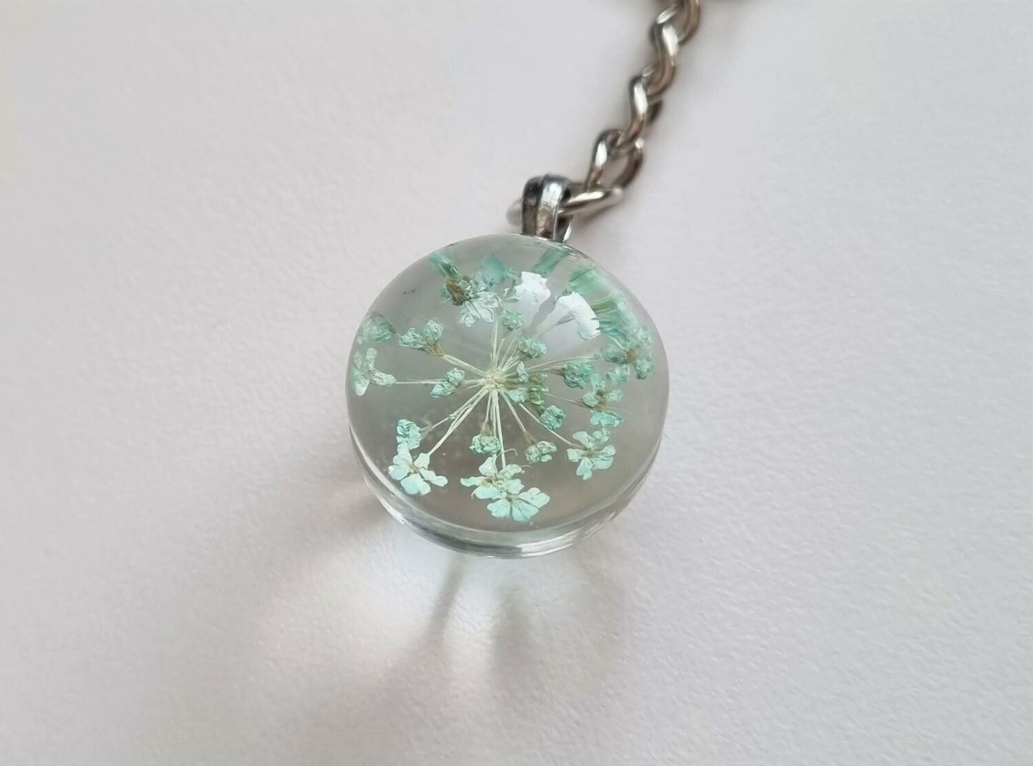 Nyckelring Glaskula glasboll med torkad blomma (turkos)