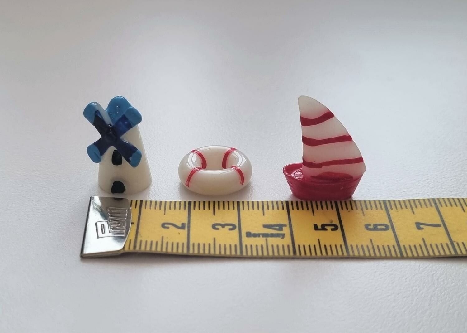 3 st miniatyrer / figuriner (segelbåt, väderkvarn och livboj) för dockskåpet