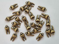 2 st tänder, tandberlocker / charms för smyckestillverkning (bronsfärgade)